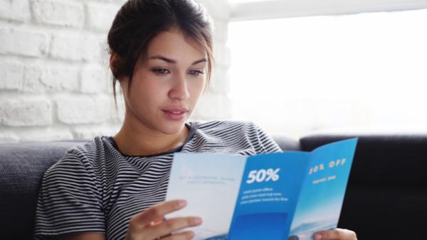 woman reading direct mail- marketing mix page